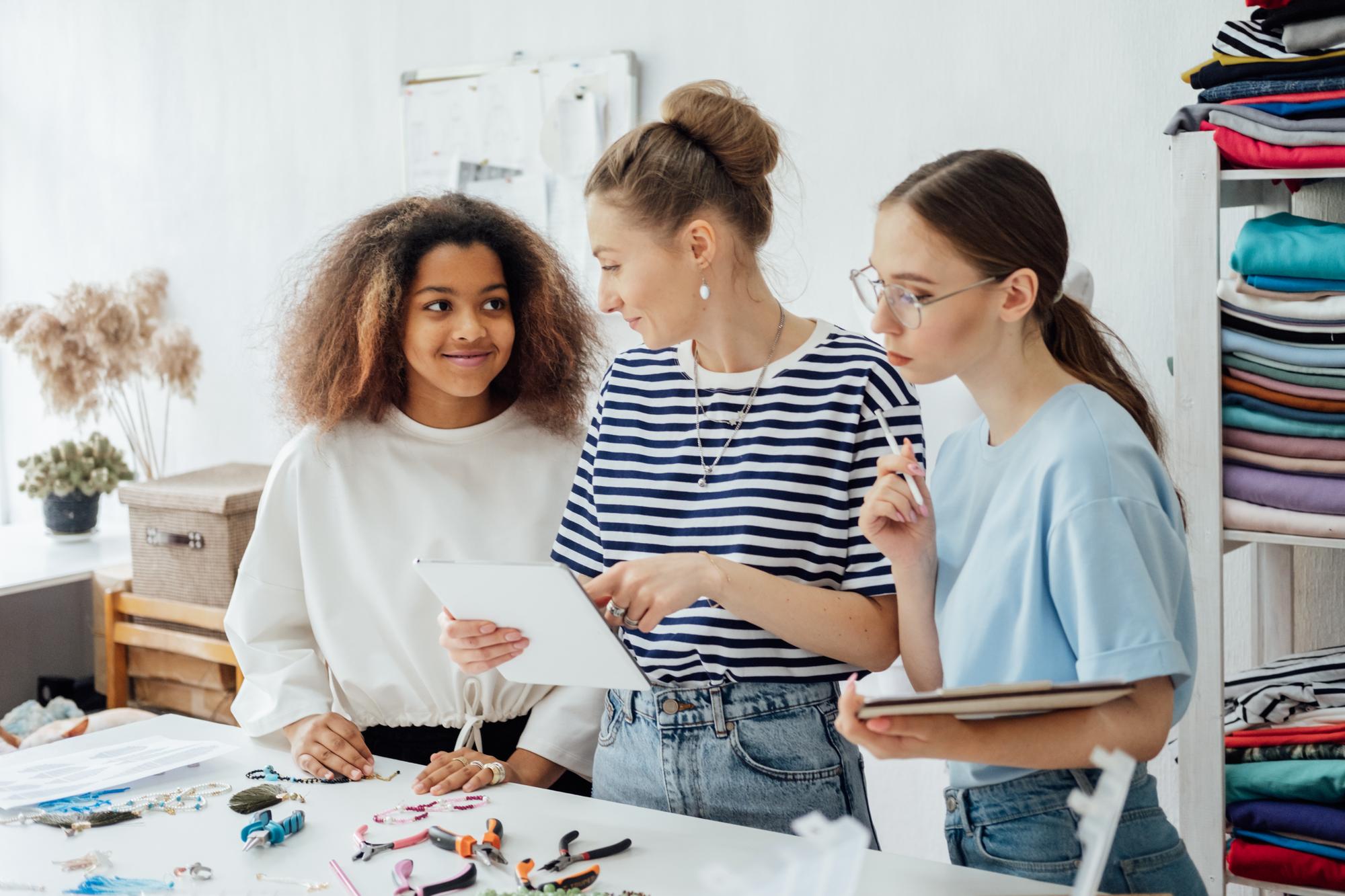 Workshop: studenti al tavolo con telai e fili